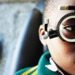 A child using a tablet with glasses, illustrating rising myopia worldwide.