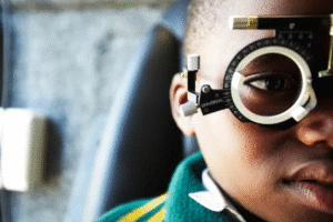 A child using a tablet with glasses, illustrating rising myopia worldwide.