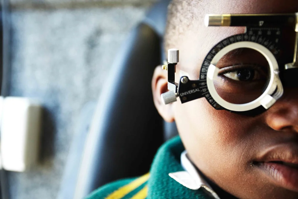 A child using a tablet with glasses, illustrating rising myopia worldwide.
