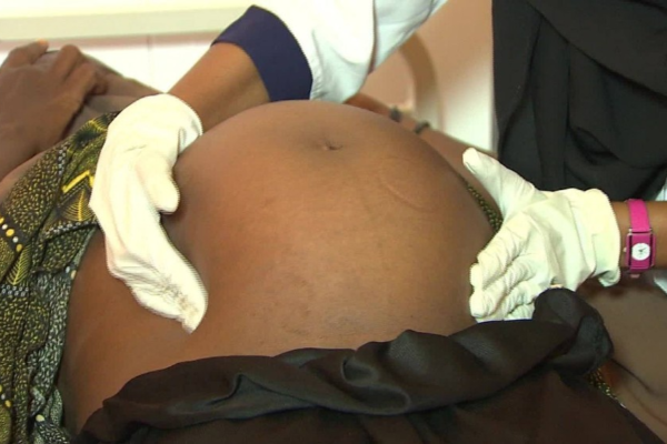 Doctors performing a caesarean section delivery in a district hospital in Rwanda